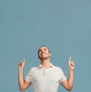 Smiling man pointing upward outdoors